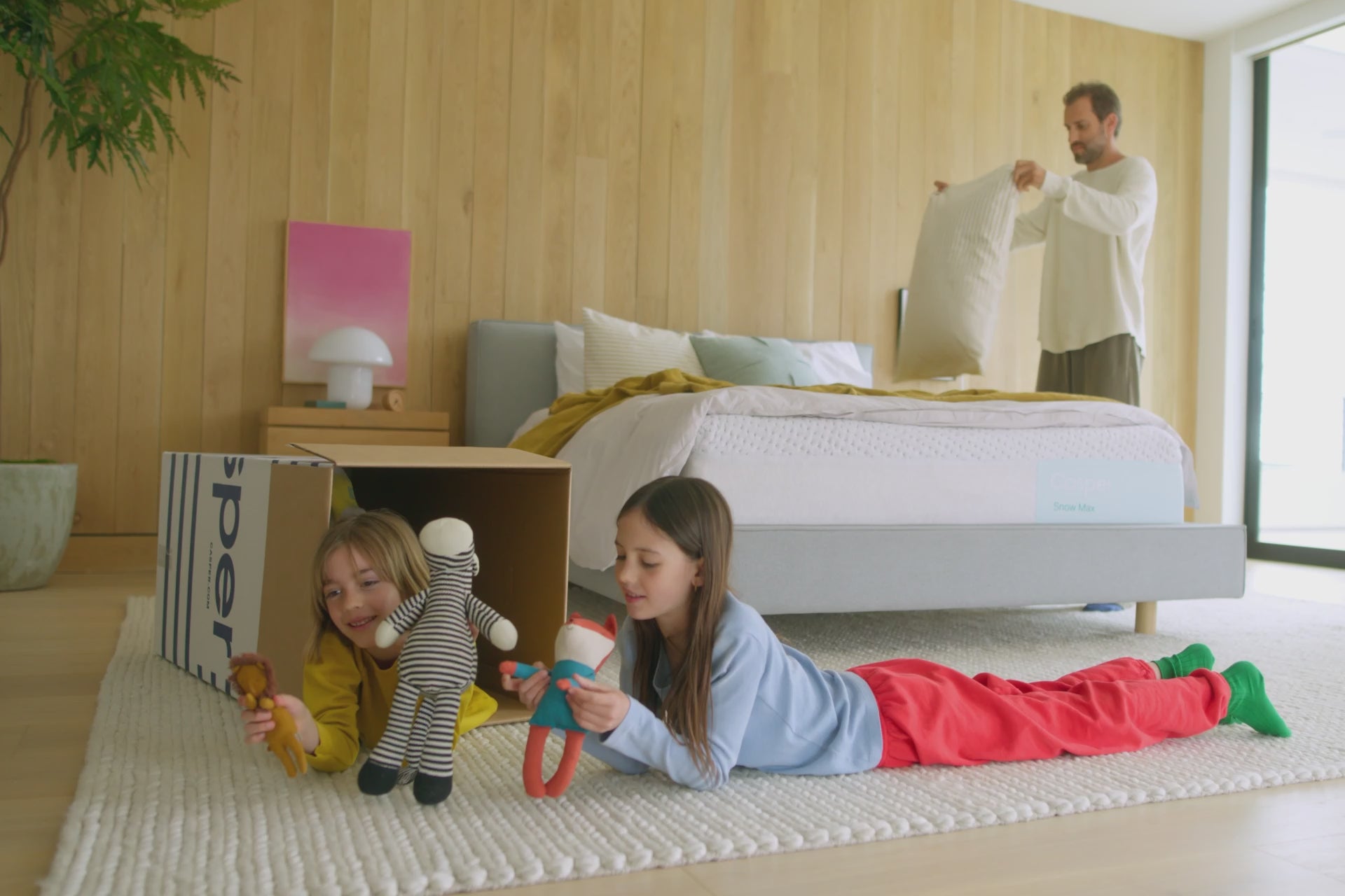 A father and his children enjoy their time in a bedroom on a Snow Max mattress.