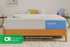 Front-view of the Casper Dream mattress on a wooden bed frame with pillows and a blanket folded on top. Beneath the image there appears a banner which says, "Consumer Reports. Highly rated hybrid mattress of 2025. See below to learn more. *Consumer Reports does not endorse products or service."