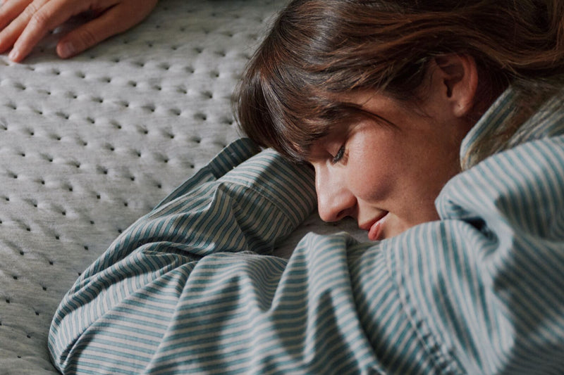 Close-up image of a woman lying on her stomach on the mattress.