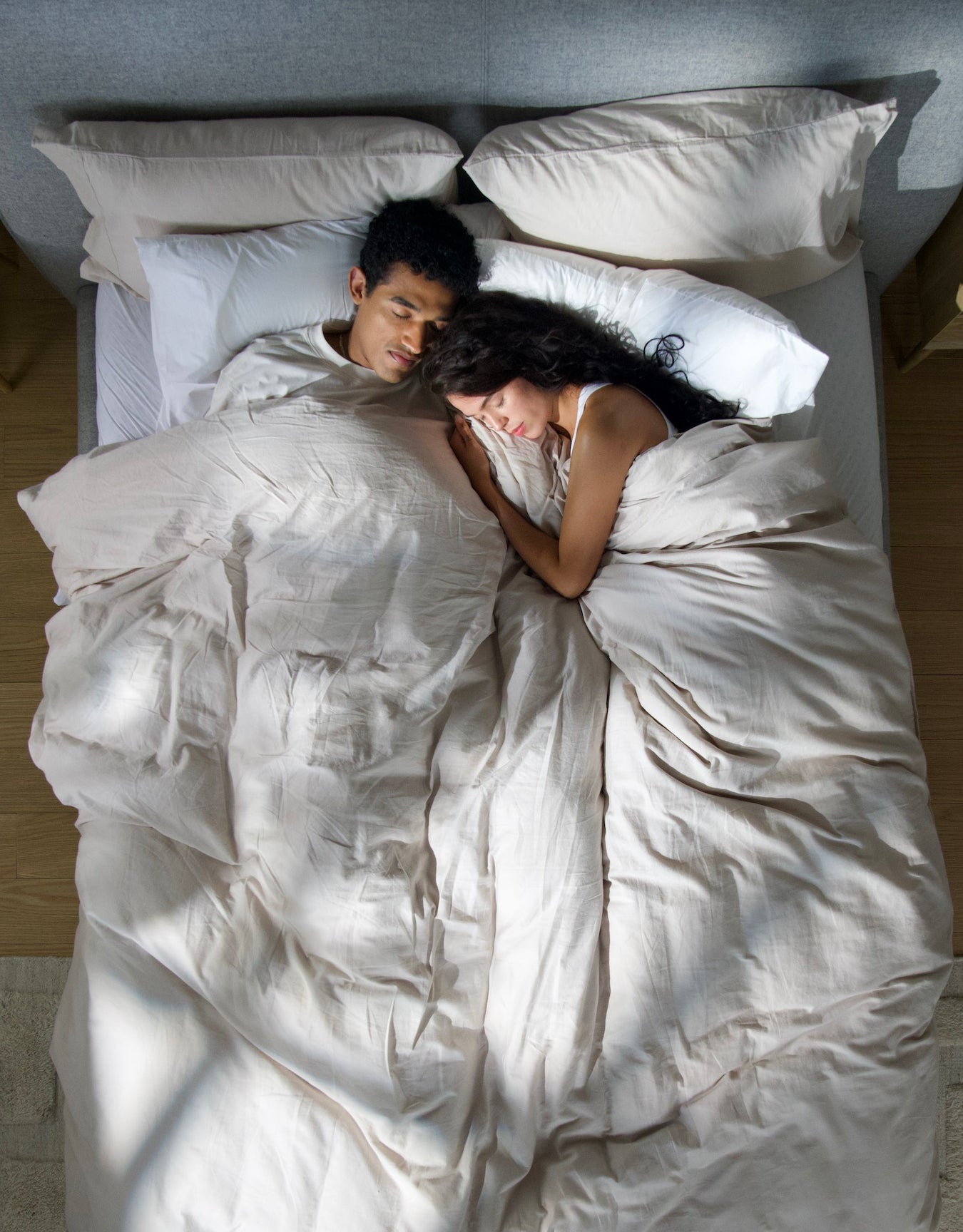 Top view of a couple sleeping in their bed.