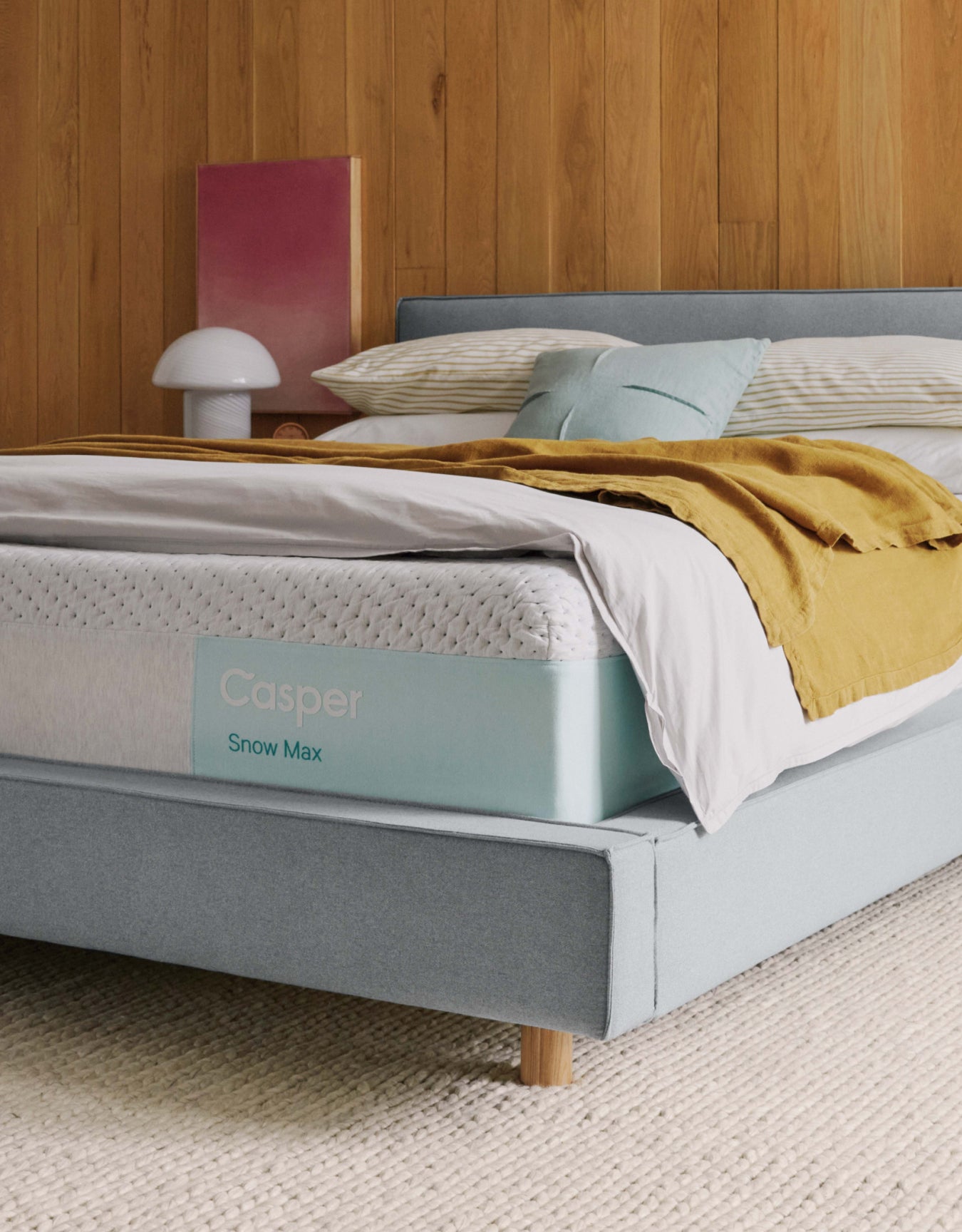 A Casper® 金刚KINGKONG游戏官网 Snow Max mattress on a bed with pillows and folded blankets on top of it