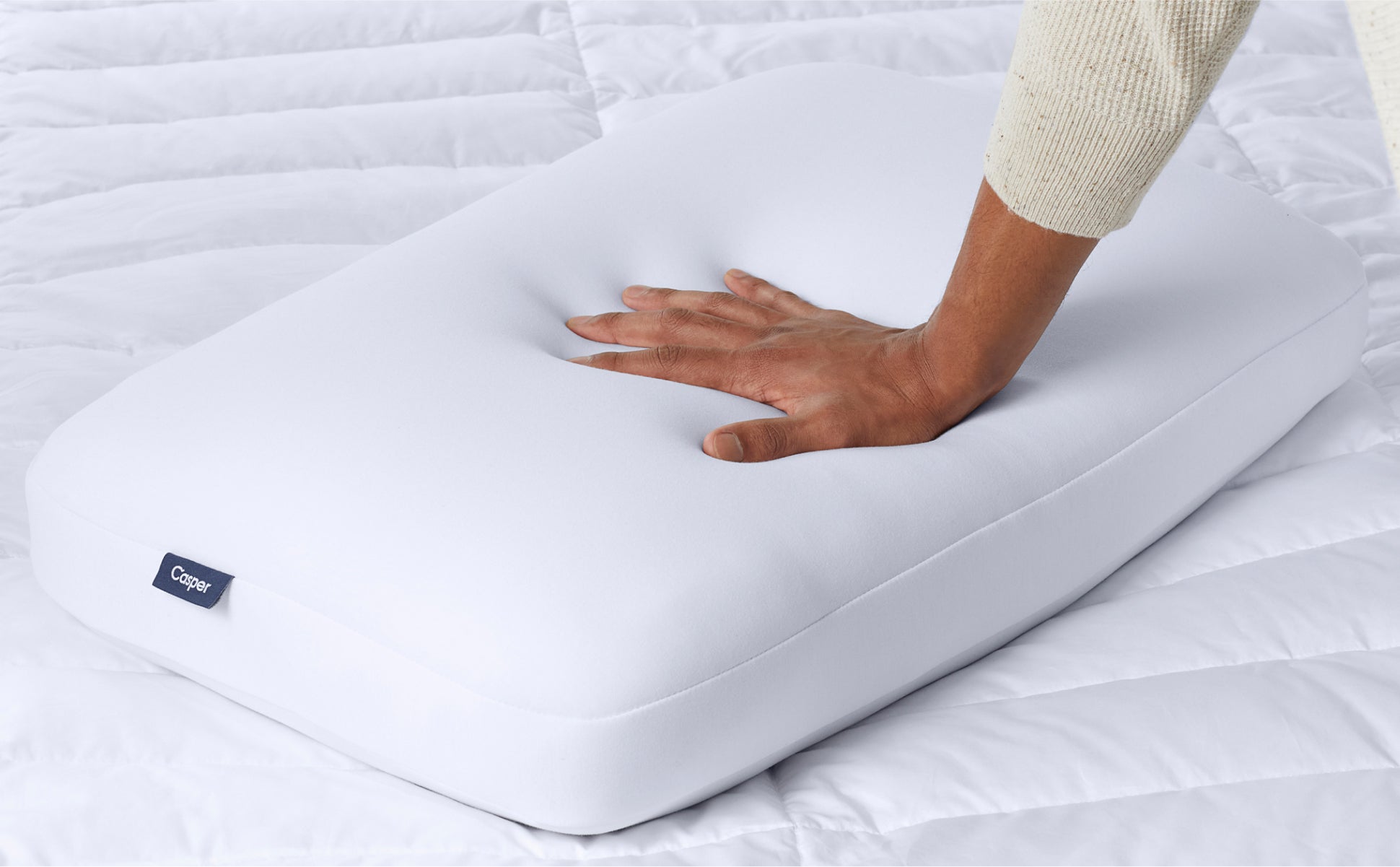 A hand feeling the Casper Foam Pillow