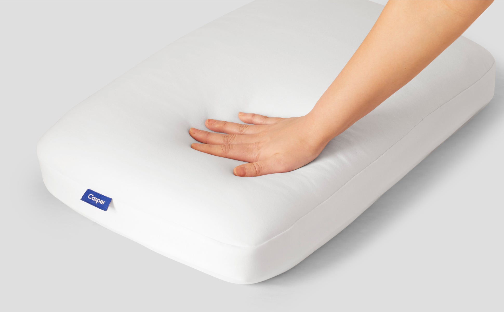 A hand feeling the Casper Foam Pillow with Snow Technology