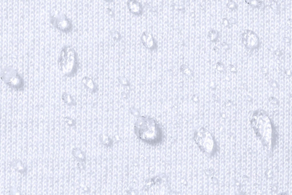 Close-up of waterproof mattress protector fabric with water droplets