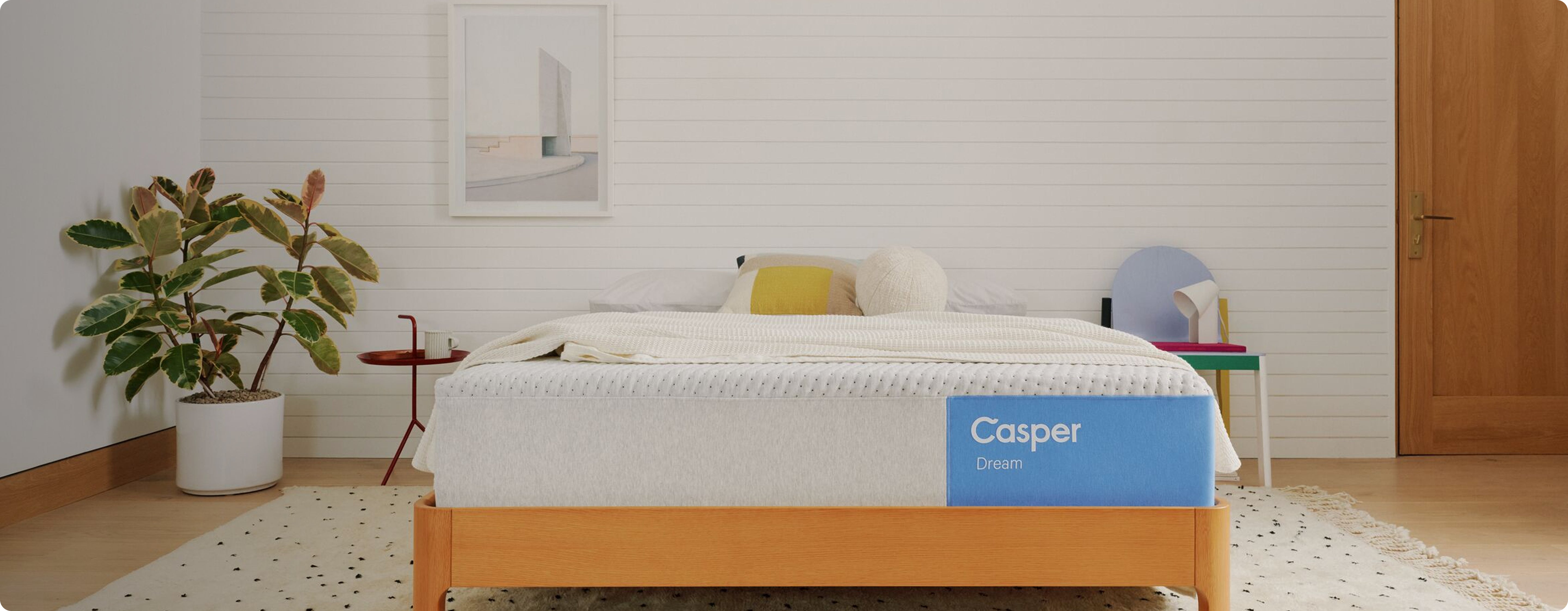 Casper® 金刚KINGKONG游戏官网 mattress in a bedroom setting with a plant and side table.
